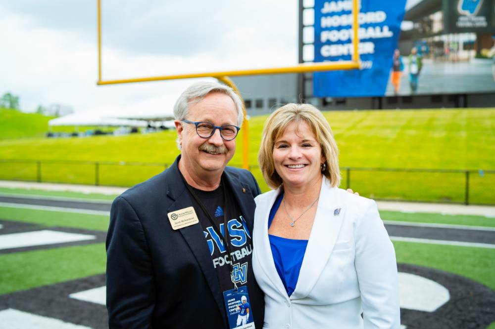 Guests posing on the field at the Jamie Hosford Football Center dedication.